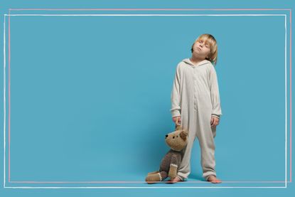 A young boy in pyjamas sleepwalking while carrying a teddy bear