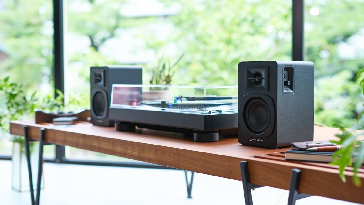 Audio-Technica AT-SP3X speakers next to a turntable on a wooden table