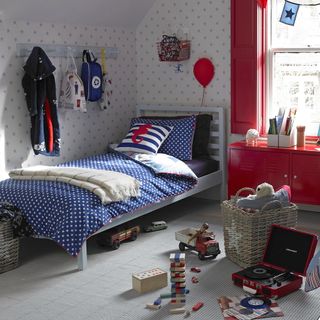 kids room with twin bed, patterned wallpaper and red shutters