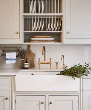 butler sink with period style brass taps and white kitchen units