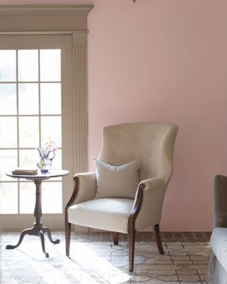 pale pink paint color on living room wall with upholstered armchair