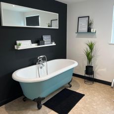 bathroom with black wall and blue roll top bath