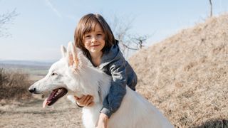 Caucasian Shepherd Dog being hugged by a young boy