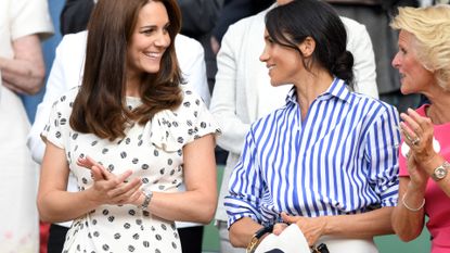 Catherine, Duchess of Cambridge and Meghan, Duchess of Sussex attend day twelve of the Wimbledon Tennis Championships at the All England Lawn Tennis and Croquet Club on July 14, 2018 in London, England.