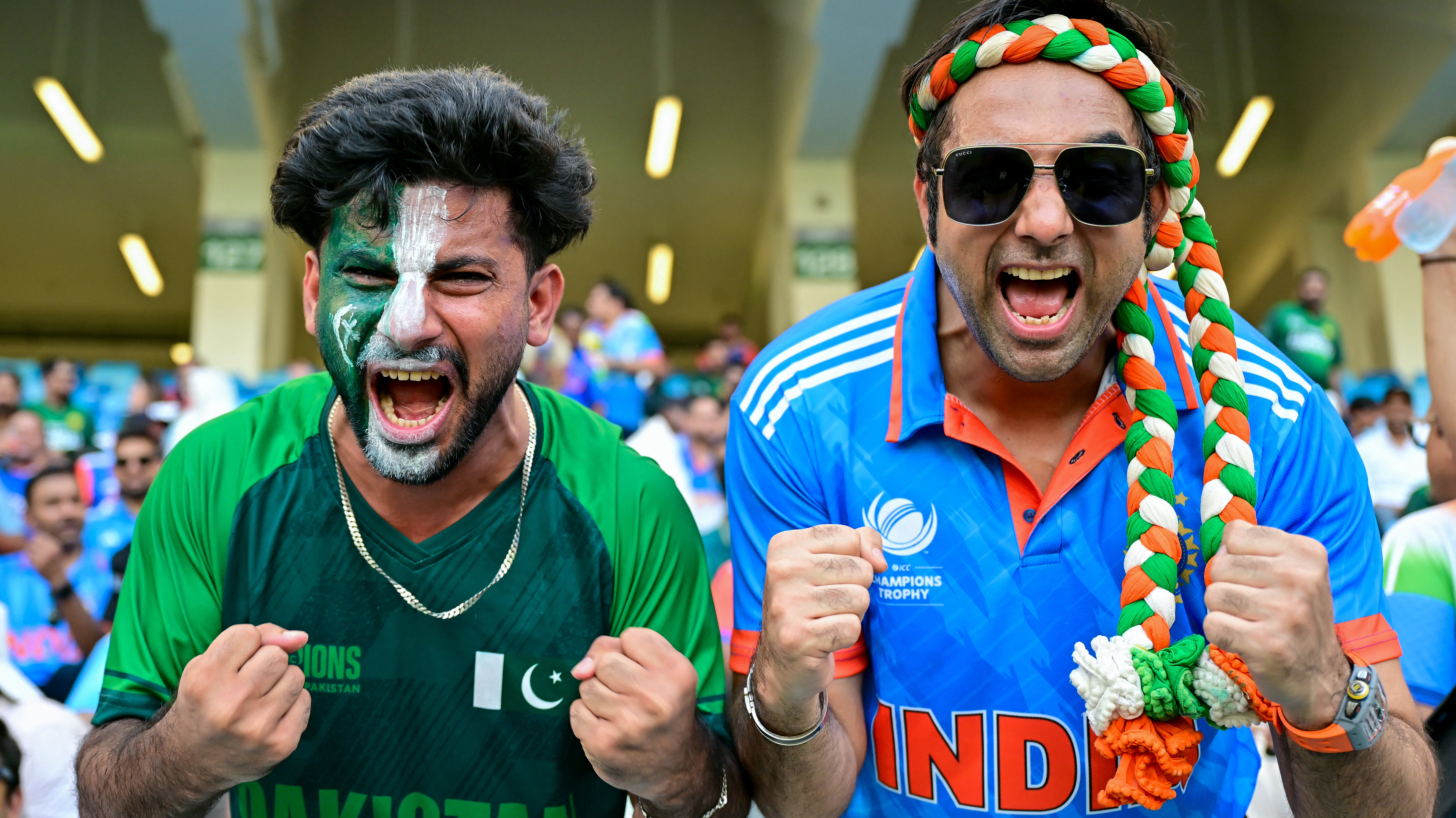 A Pakistani and an Indian fan pose for a photo before the start of the Asia Cup 2025 Twenty20 international cricket final between India and Pakistan at the Dubai International Stadium in Dubai on September 28, 2025. 