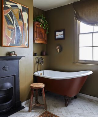 A green bathroom with gray herringbone floor tile