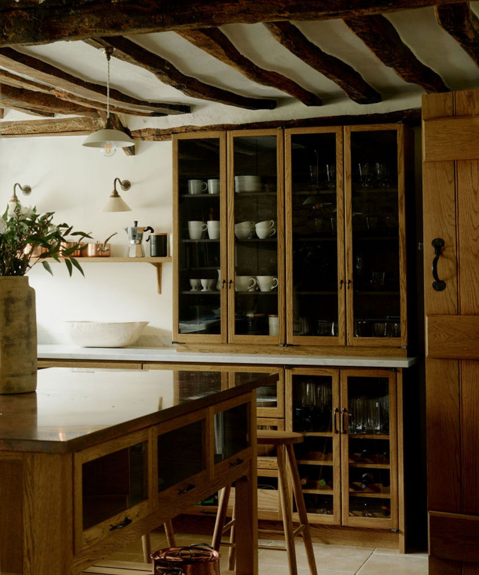 A country kitchen with wood cabinets and traditional porcelain lighting