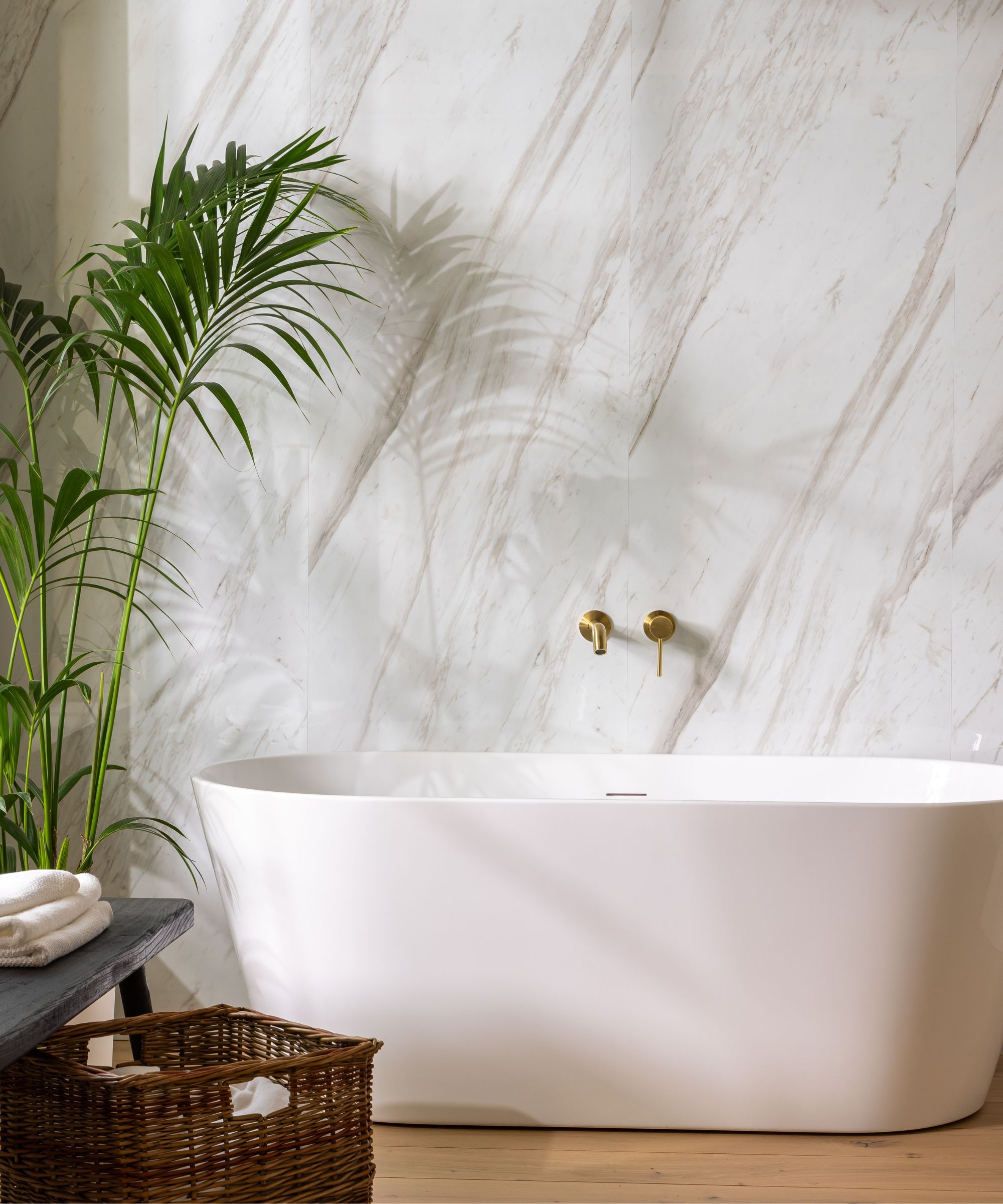 A freestanding bath with marble effect wall panels