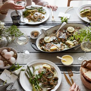 dining table with plates and bowls with spoon and glasses with foods