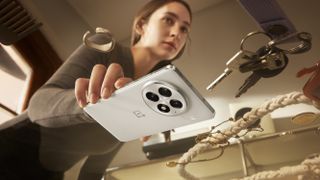 A woman setting the OnePlus 13 down on a table