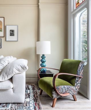 A vintage Jindrich Halabala armchair has been upholstered in fabrics of densely embroidered leaves and moss-green velvet. The side-panel detail accentuates the shape of the chair and makes it feel like new.