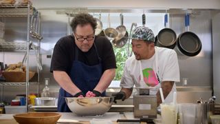 jon favreau and roy choi using their hands to mix something on the chef show