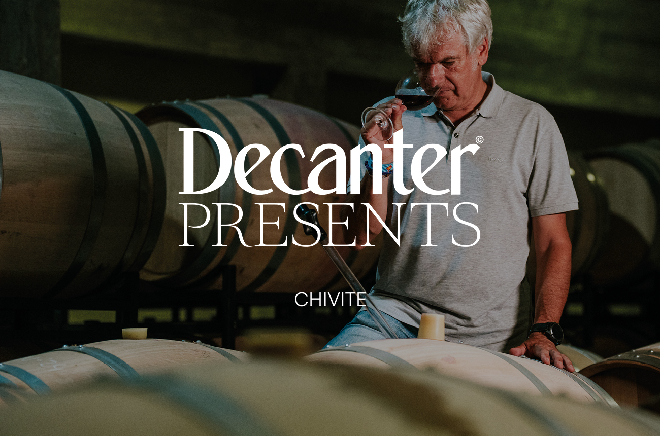 winemaker David Gonz&amp;aacute;lez sniffing red wine amongst barrels