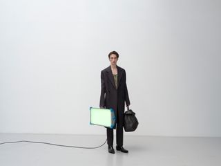 Man holding lightbox in Bottega Veneta outfit