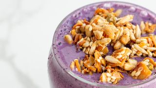 The Blueberry and Peanut Butter Smoothie served in a glass cup topped with granola