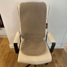 Stoov Big Hug3 on a cream office chair with arms in front of a white wall and on a wood-look floor