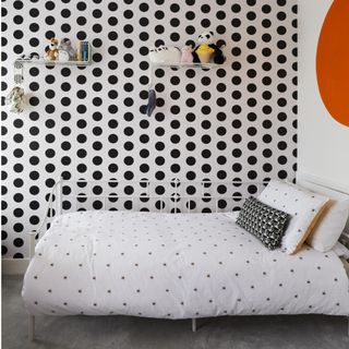 bedroom with white polka dots, orange circle and white bed