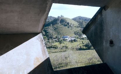 View from window of concrete room overlooking valley