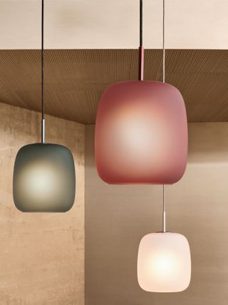 Three pendant lights with pink, green and white frosted glass shades