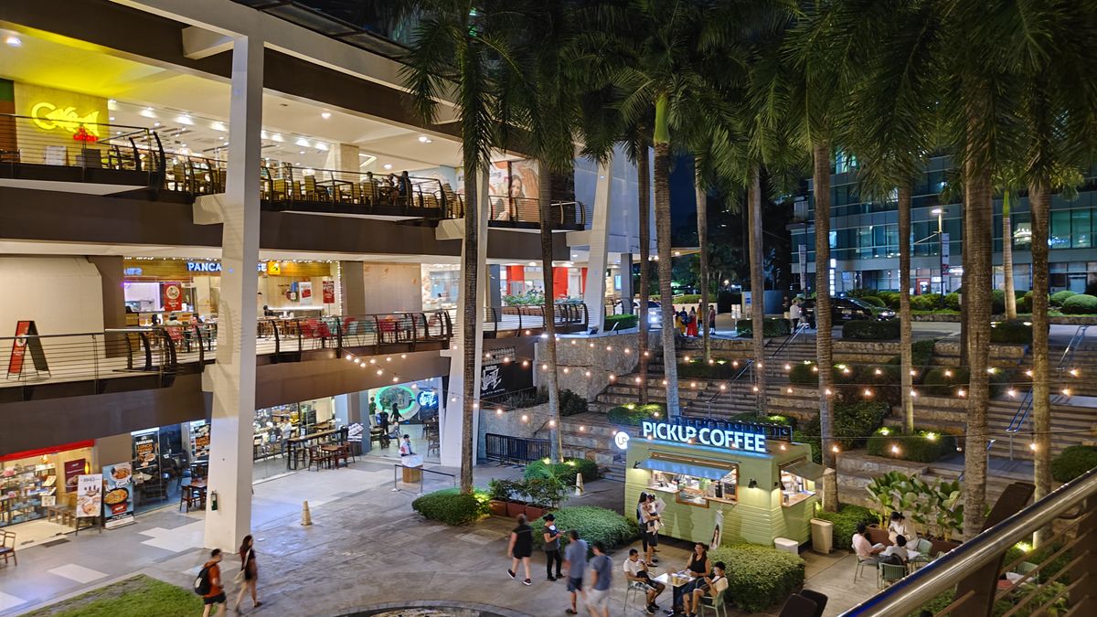 A bustling mall with shoppers strolling around and browsing through various stores.