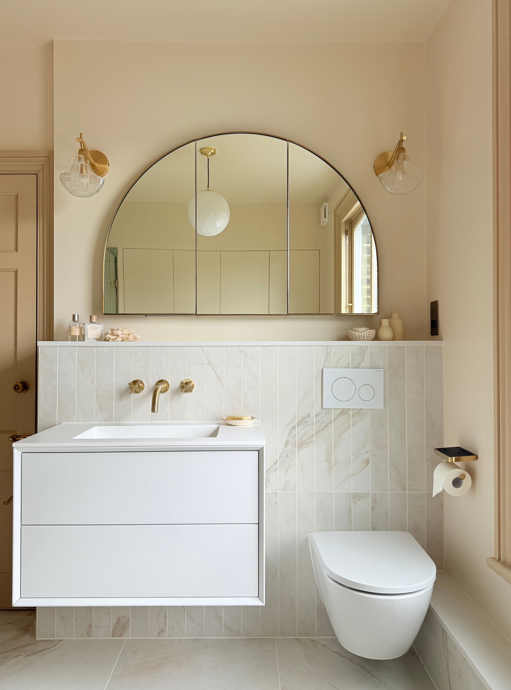 Cream bathroom with hidden storage in arched mirror