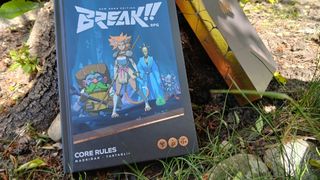 Break!! rulebook and box on a patch of grass, leaning against a tree