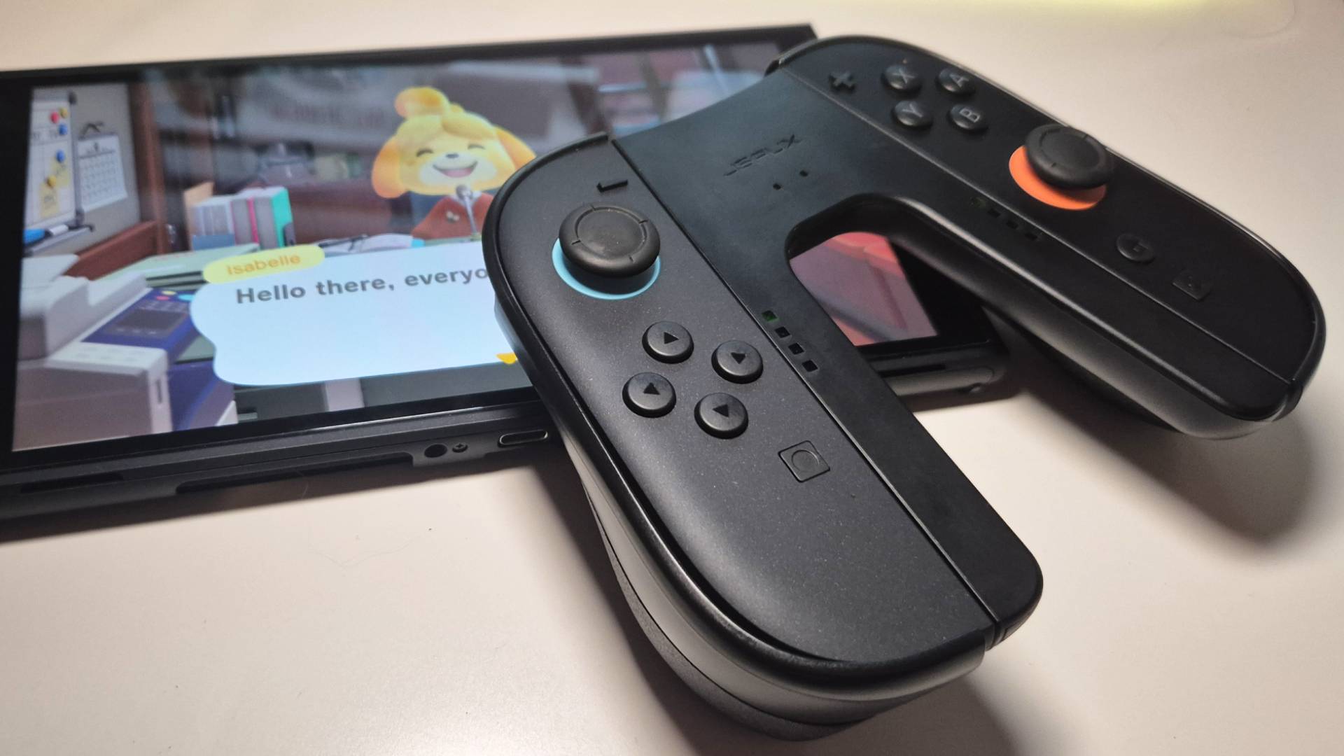 Photo of a pair of Switch 2 Joy-Con resting on the handheld with the Charging Grip attached.