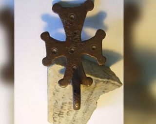 This Maltese cross pendant is from between the first and seventh centuries from Shivta; the Shivta pottery shard inscribed with early Arabic script, dates to the eighth or ninth century.