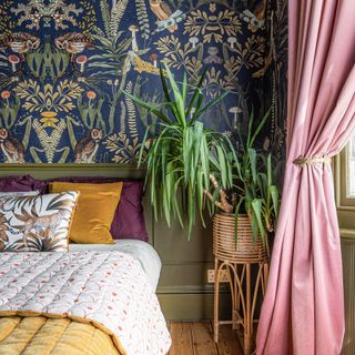 Blue wallpaper with pink curtains and yellow quilt on bed