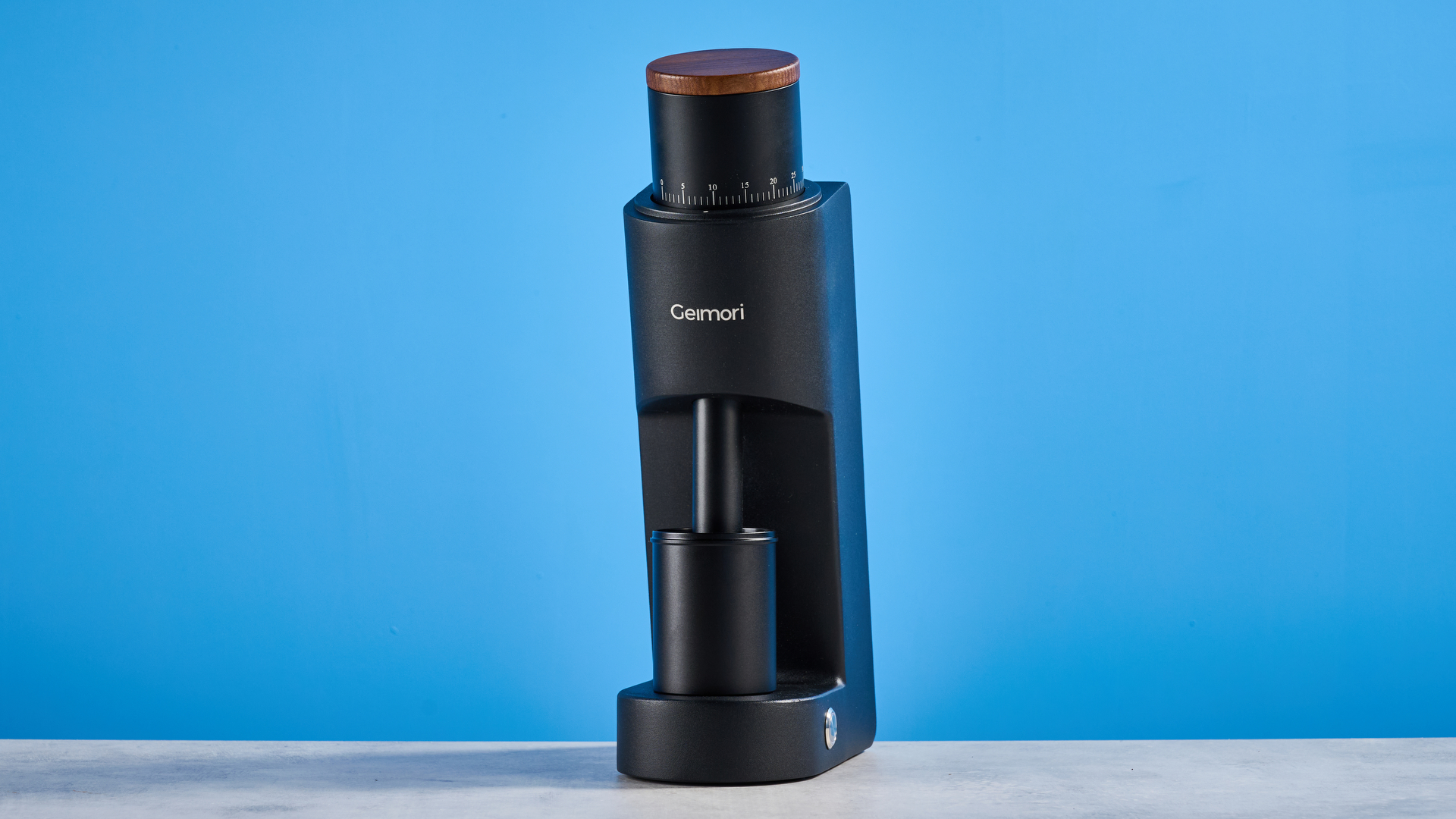 the wirsh geimori gu38 coffee grinder in black with a walnut hopper lid photographed against the blue tom's guide background