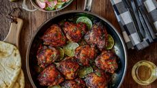 The Hestan NanoBond Skillet on a wooden counter, filled with fried chicken chunks and lime slices