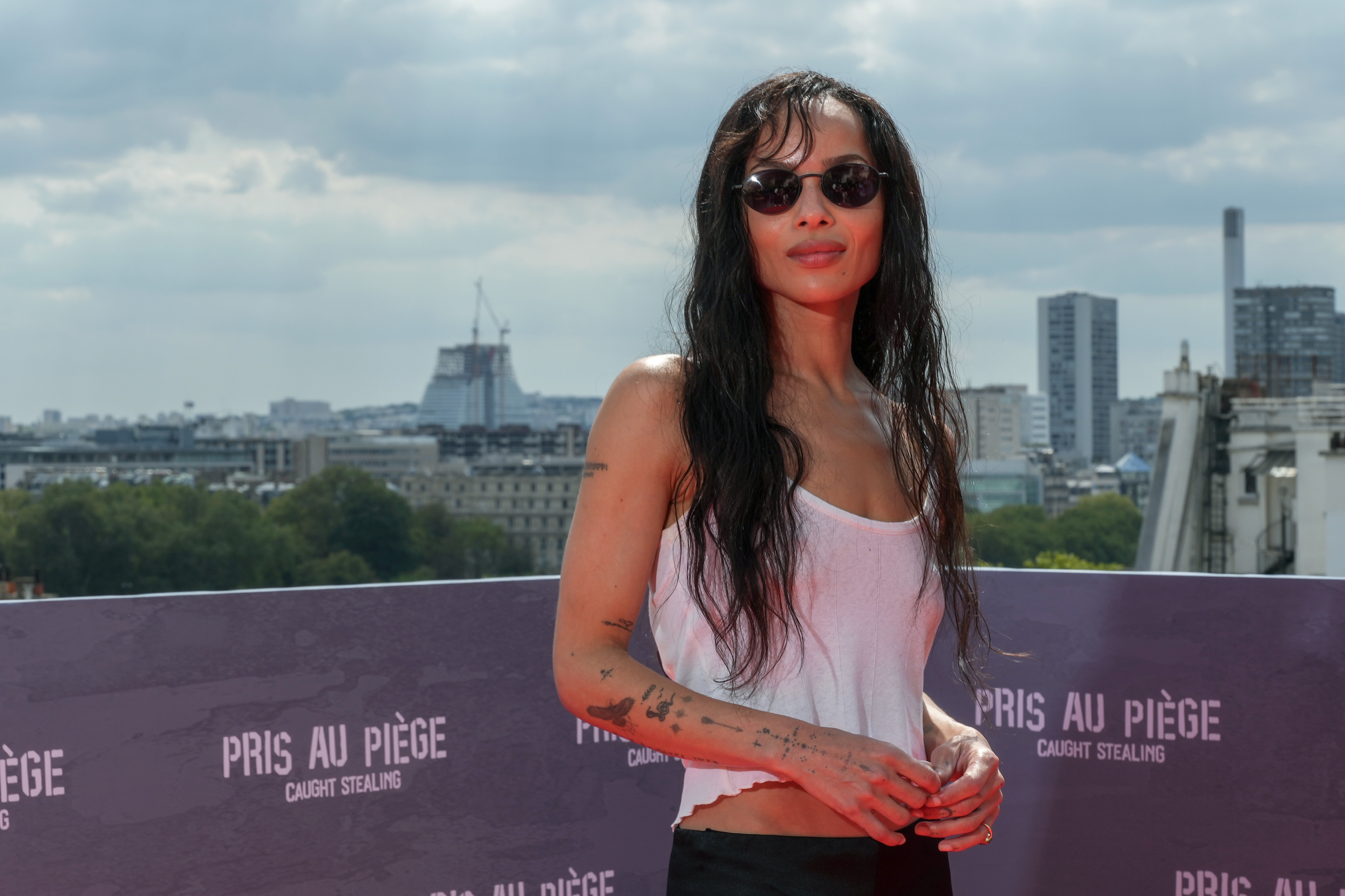 zoe kravitz wearing a white tank top and black sunglasses