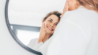 Woman applying moisturiser to her face