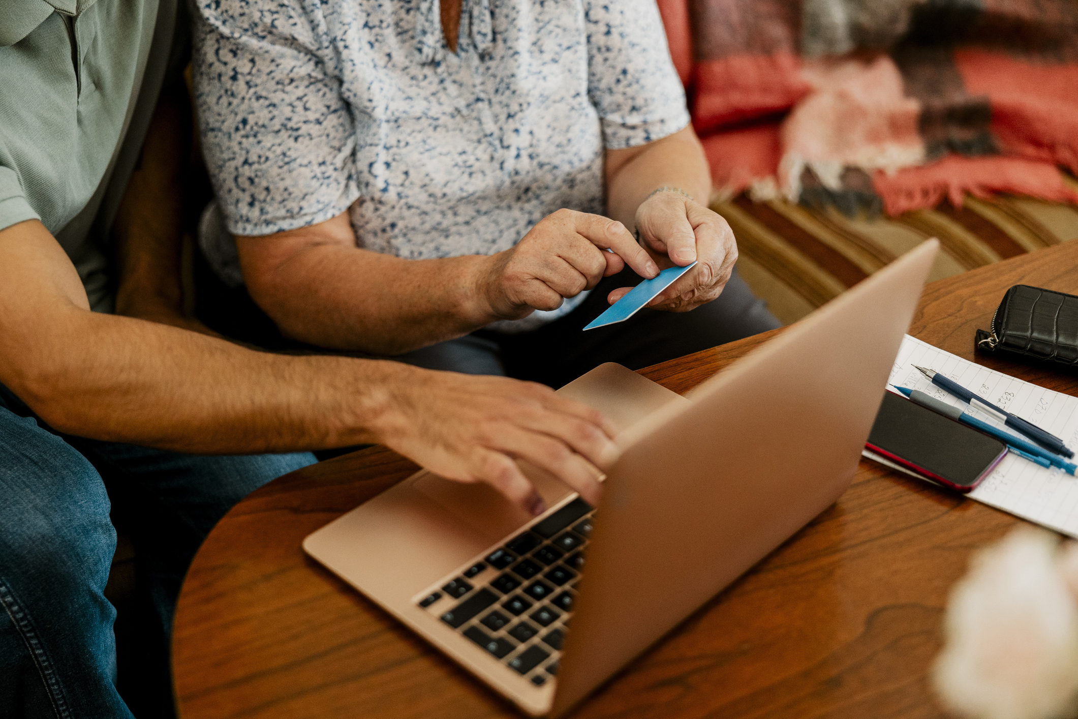 A couple discussing their credit card strategy in front of an open laptop