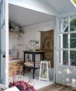 Relaxed garden room in Scandi neutrals, styled with lanterns, and relaxed cushions for a cozy garden retreat.