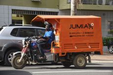 A delivery man drives a transporter with an advertisement for Nigeria's e-commerce site Jumia