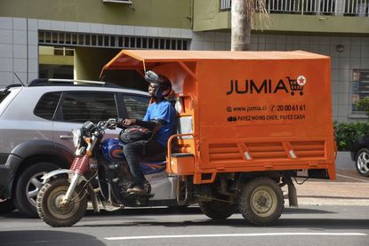 A delivery man drives a transporter with an advertisement for Nigeria's e-commerce site Jumia