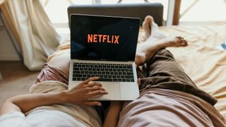 Pareja viendo Netflix en el portátil en la cama