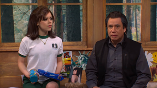 Fred Armisen and Jenna Ortega sitting on a bed and talking during an SNL sketch.
