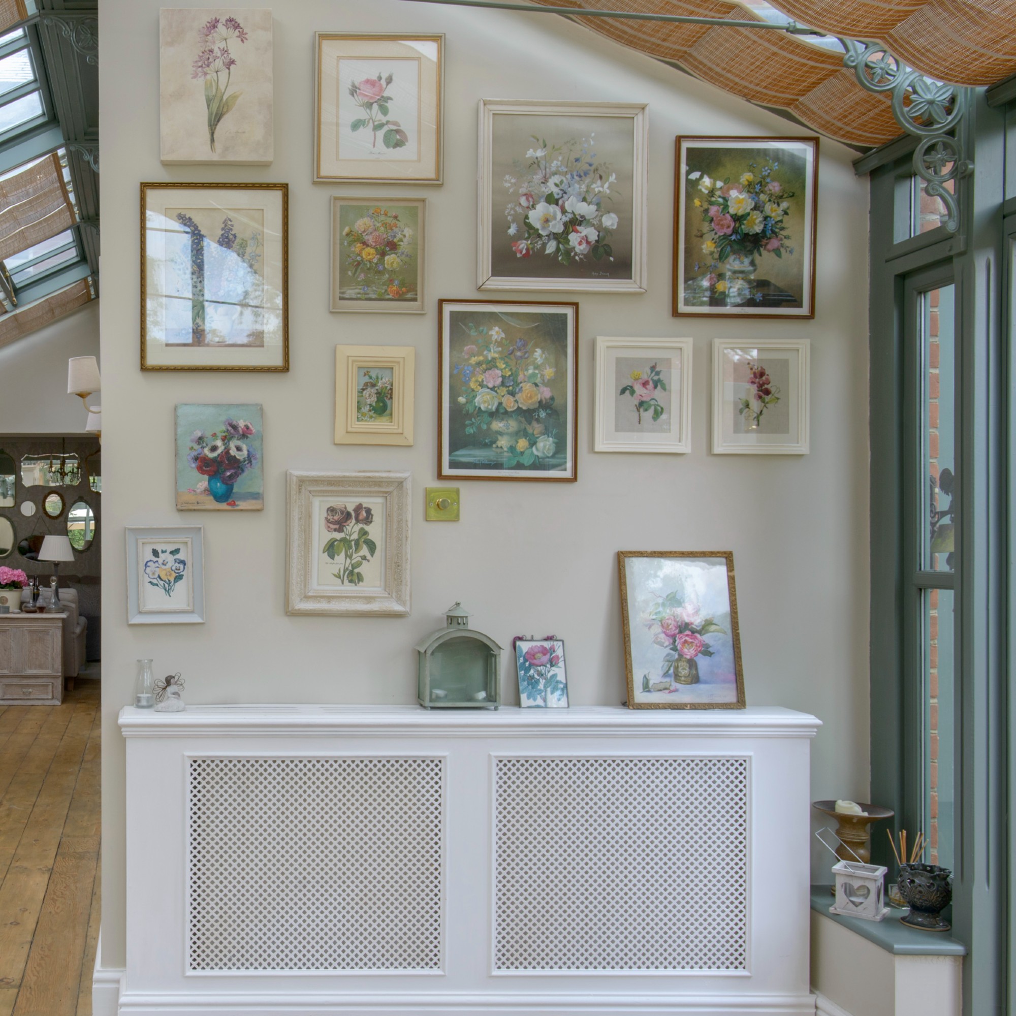 A conservatory with a gallery wall of floral art pieces