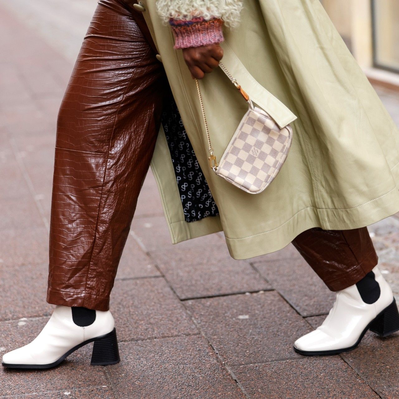 Influencer Lois Opoku wearing a mini bag by Louis Vuitton and white Chelsea boots by Monki, seen during Copenhagen Fashion Week Autumn/Winter 2022 on February 2, 2022 in Copenhagen, Denmark.