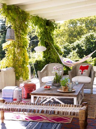 patio cover ideas for white awning with colorful furniture and climbing plants