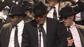 Jimmy Fallon dressed as a Blues Brother with dancers at SNL50: The Homecoming Concert