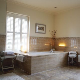 bathroom with brown tiles and bathtub