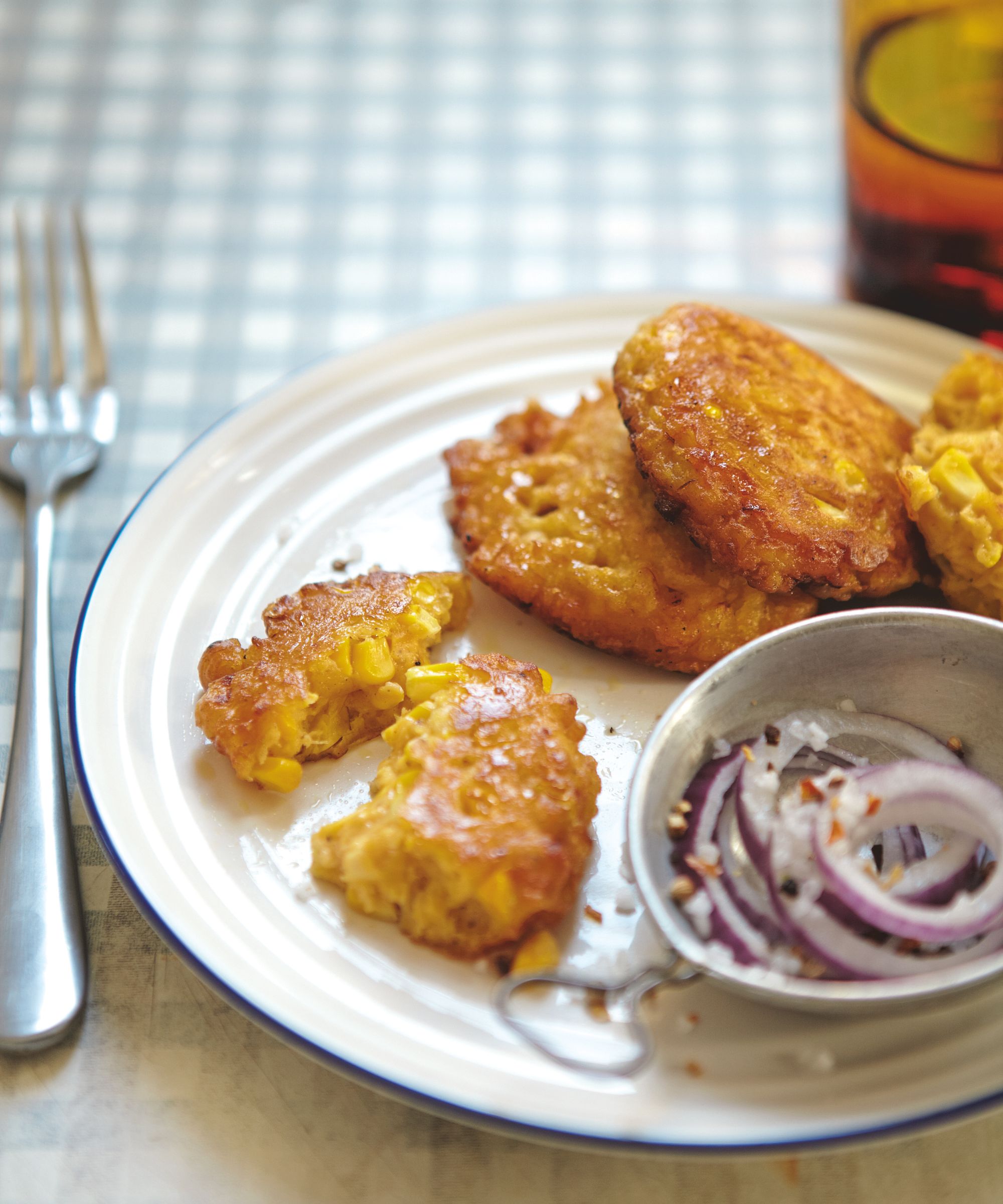 Sweetcorn fritters on a plate with onion garnish