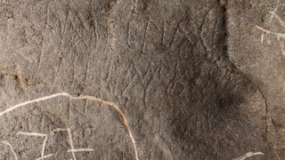 Close up image of Roman inscriptions on the walls of a cave.