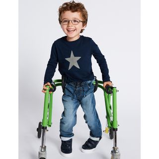 kid wearing blue tshirt and jeans trouser on wheeled chair