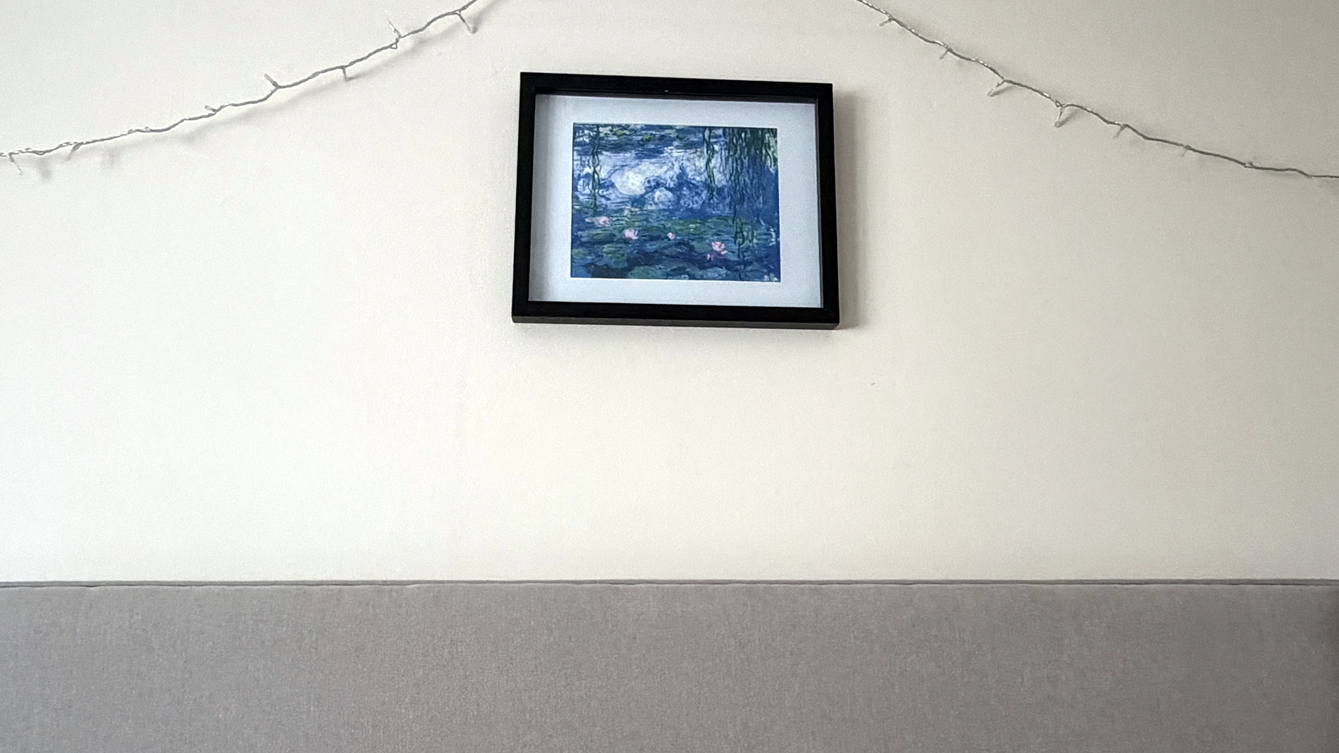 A picture of a water color painting in a frame above a headboard on the wall in sleep writer Ruth Jones' bedroom