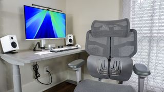 The Hinomi X1 ergonomic office chair in front of a desk setup on the Hinomi S1 electric standing desk
