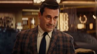 Jon Hamm looks down slightly as he approaches the reception desk in Bad Times at the El Royale.
